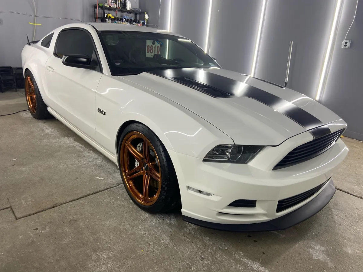 White Ford Mustang GT with black stripes and bronze wheels