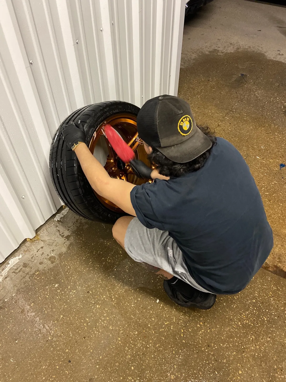 A shop technician brushing the inside of a bronze wheel